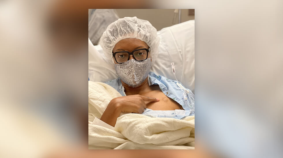 Gigi in hospital gown with mask on 