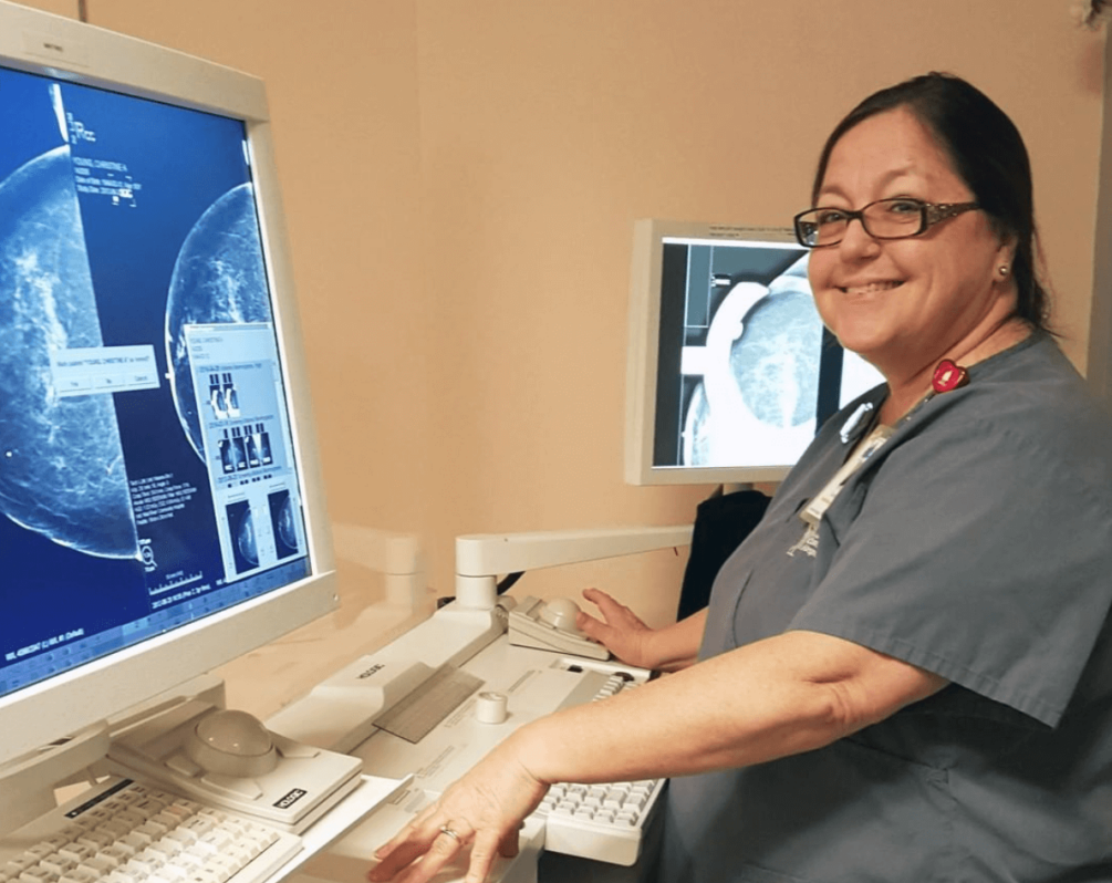 Woman in scrubs at a computer