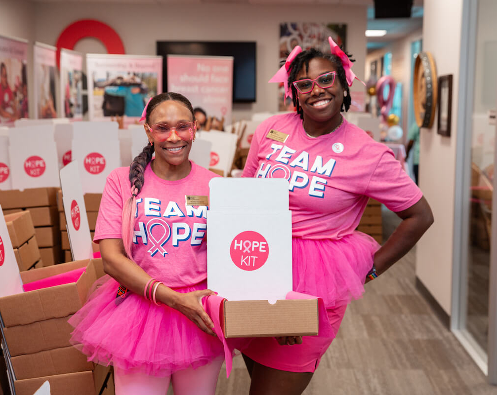 Two women dressed in pink with a hope kit box