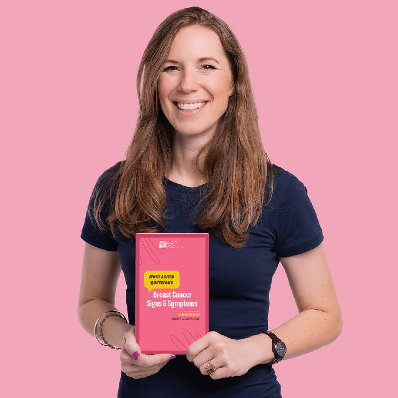 Woman holding book of most asked questions about signs and symptoms of breast cancer.