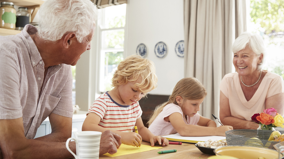 Grandparents smiling and coloring with grandkids