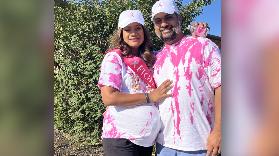 Photo of pregnant Anuradha and her husband, wearing pink shirts