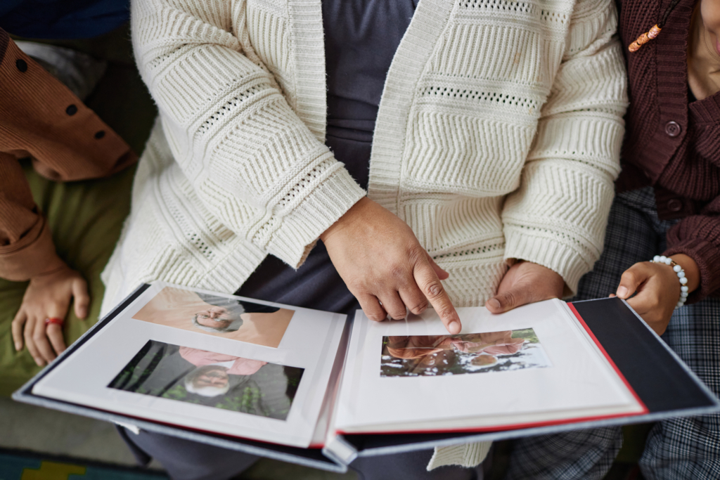 Picture of a woman looking at and pointing to a photo album