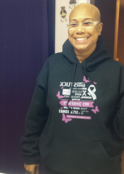 Alene bold head in a hoodie promoting breast cancer awareness