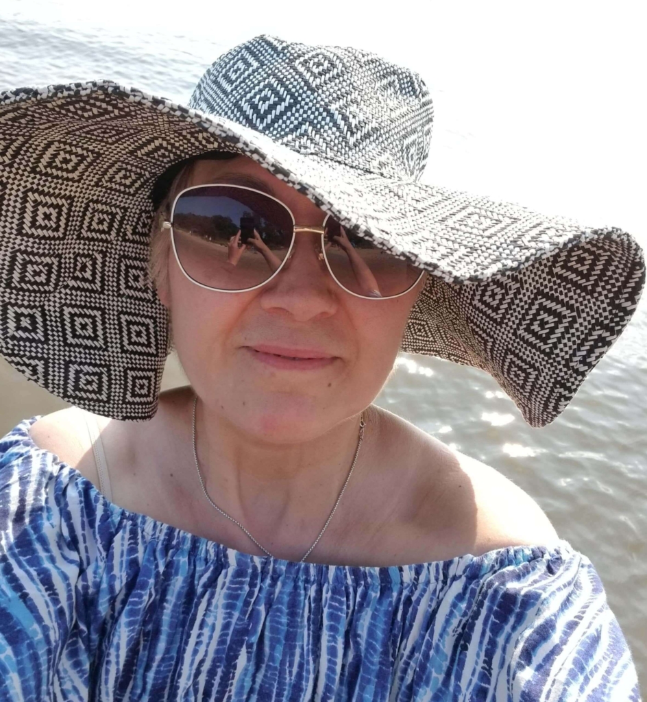 Karla at the beach with a hat 