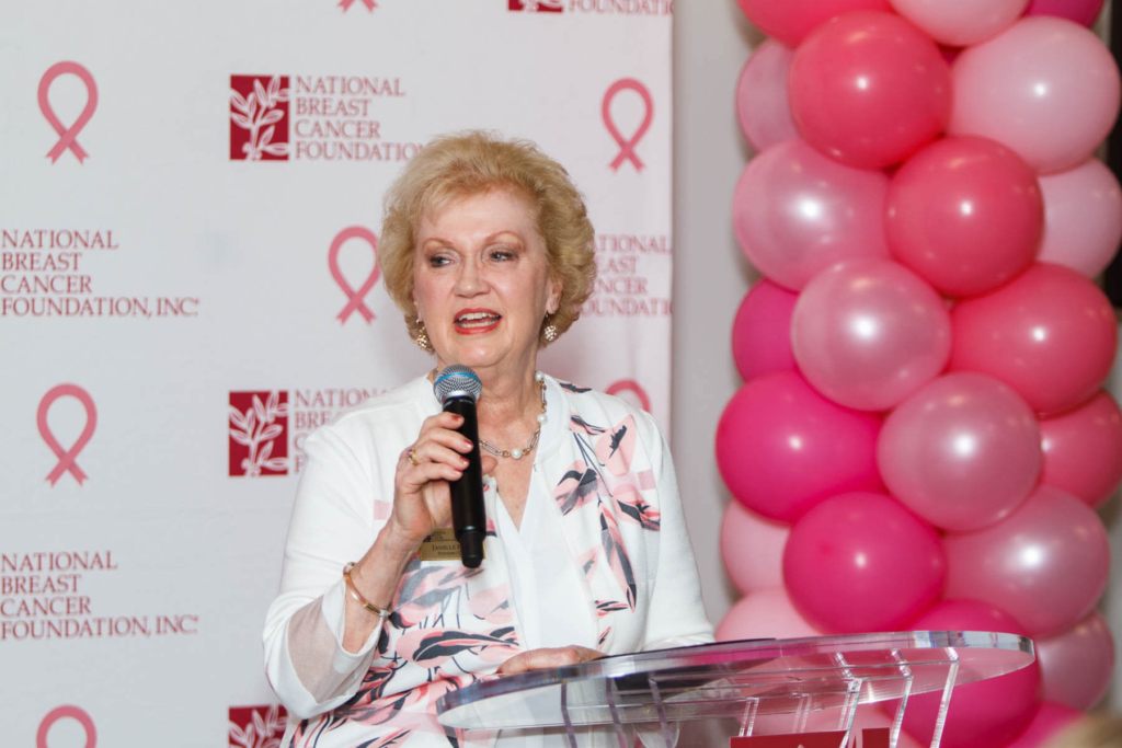 Janelle Hail, founder and CEO of the National Breast Cancer Foundation giving a speech with pink balloons in the background