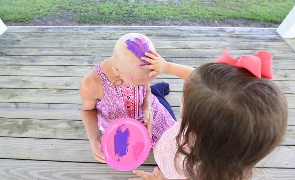 Sheri and one of her grand daughters paining her bald head 